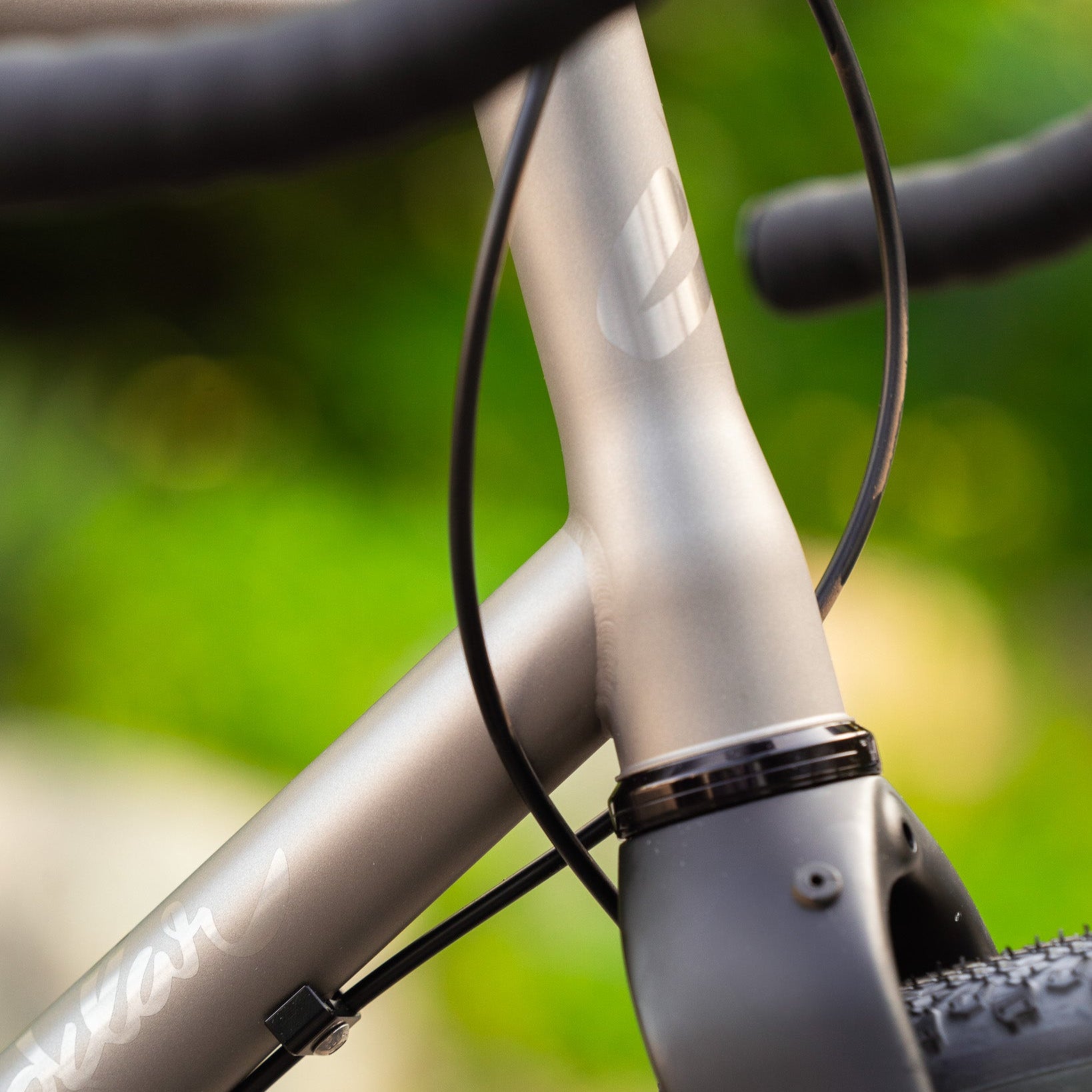Close-up of a bicycle frame with blurred green background