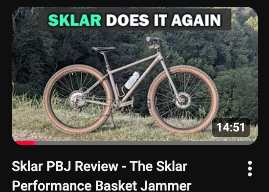 Bicycle with Sklar Performance Basket Jammer in a grassy area, with text overlay about the product.